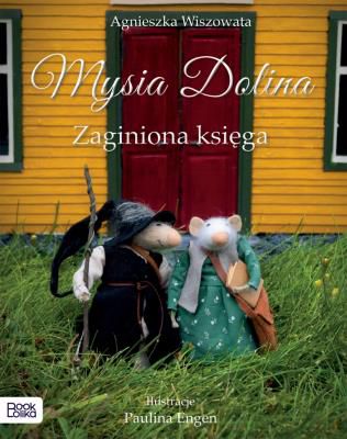 Myszka MO jest młodą archiwistką. Spisuje losy Mysiej doliny. Jednocześnie Mo chce poznać historię swego poprzednika Hugo, który zniknął wraz z księgą opisującą jego losy. Księga oraz tajemnica zaklęcia milczenia, która spadła na MO to zadanie, któremu musi sprostać. Wzruszająca, pełna magii opowieść o sile przyjaźni, wytrwałości i dążeniu do sprawiedliwości. Historia małej myszki, która odnajduje odwagę by zmienić świat. Do niezwykłego świata Mysiej Doliny i jej mieszkańców zapraszają - Agnieszka i Paulina – przyjaciółki, które od dziecka tworzą bajkowe postacie. Znają wszystkie tajemnice myszek, powstających w pracowni Pauliny. A jest ich całe mnóstwo – i tajemnic, i myszek – jak to w mysich rodzinach. Dlaczego warto sięgnąć po Mysią Dolinę? 1. Niezwykłe unikalne ilustracje – zdjęcia bohaterów (filcowanych myszek) wykonywanych ręcznie przez autorkę ilustracji, która aranżuje sceny wydarzeń w ręcznie wykonanej przez nią scenografii miniaturowego świata Myszkowa. 2. Urok i niezwykła atmosfera miniaturowego świata myszek w strojach w stylu vintage w prawdziwym leśnym mchu. 3. Wzruszająca historia o lojalności, przyjaźni i dążeniu do sprawiedliwości.